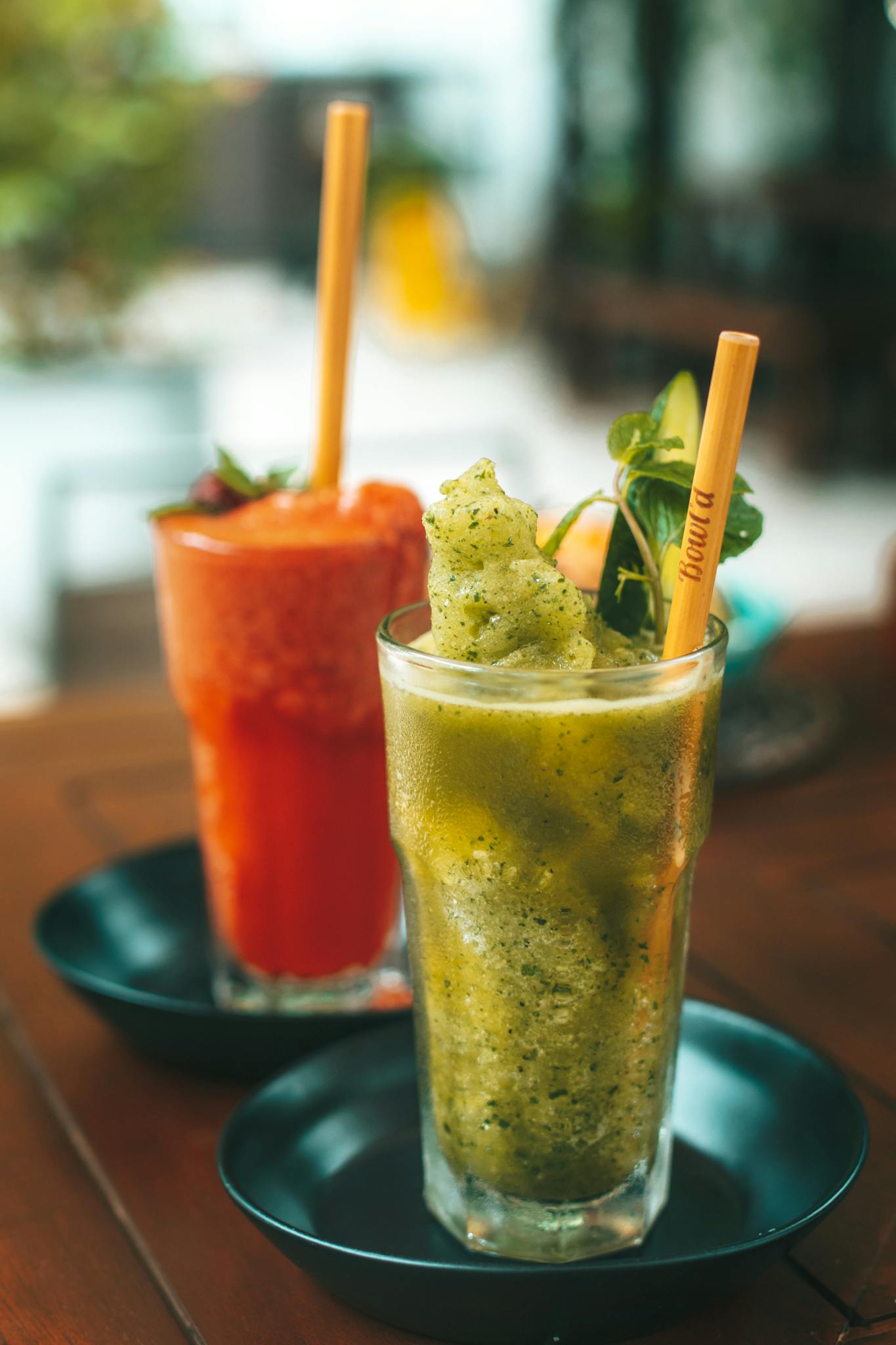 Chilled fruit smoothies with mint and bamboo straws for a refreshing summer drink.