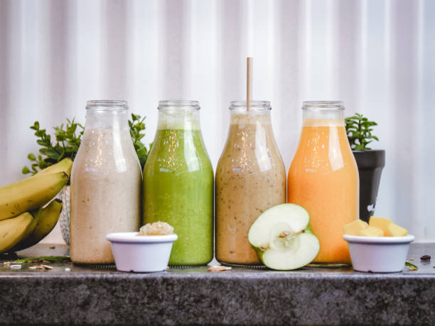Four bottles filled with juice made of vegetables and fruits